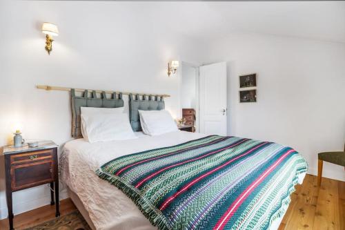 una camera da letto con un letto con una coperta colorata sopra di Chalet Futuro Terrace Sea View a Estoril