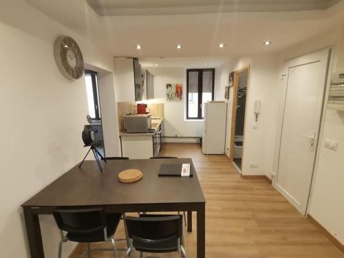 une cuisine avec une table et des chaises dans une pièce dans l'établissement lahoré djadja, à Reims