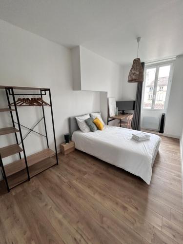 une chambre avec un lit blanc et un parquet dans l'établissement Spacieux appartement Bordeaux, à Bordeaux