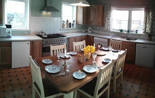 een keuken met een houten tafel met stoelen en een eetkamer bij Airebroc House in Uig