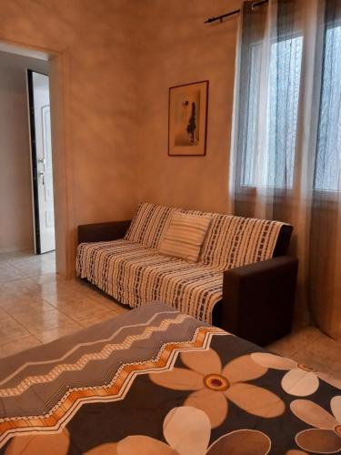 - un salon avec un canapé et une fenêtre dans l'établissement Maria house, à Athènes