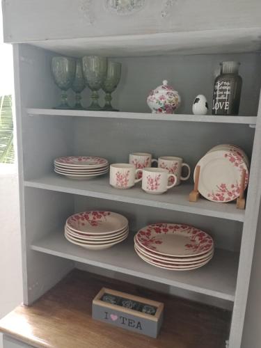 a shelf filled with plates and cups and dishes at Solar Lisboa 100 m da Praia com vista para mar in Balneário Camboriú