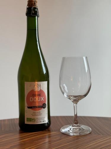 une bouteille de vin verte à côté d'un verre dans l'établissement L'hydrangea, à Danvou