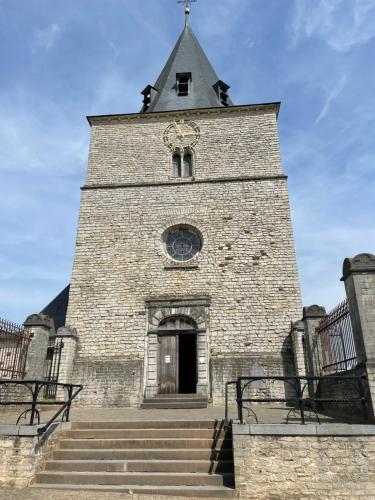 a tall brick building with a steeple on top of it at Cosy house in a charming village in Beauvechain