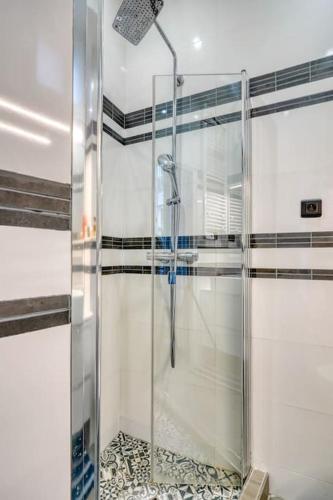 une douche avec une porte vitrée dans une salle de bain dans l'établissement Pretty apartment close to Montmartre, à Paris