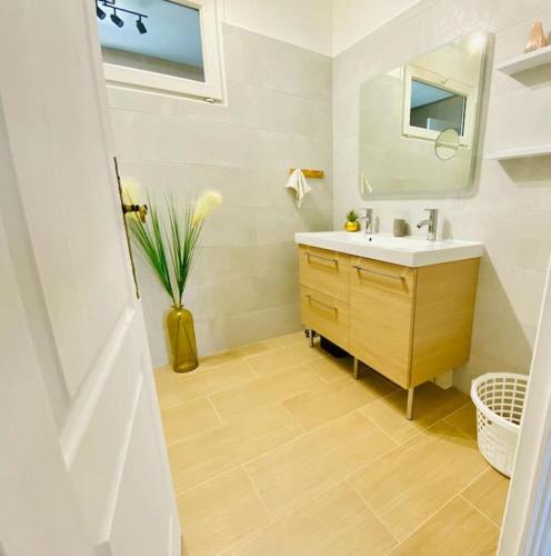 une salle de bain avec un lavabo et un vase de fleurs dans l'établissement Maison avec piscine intérieure chauffée à 10min de Biarritz, à Ahetze