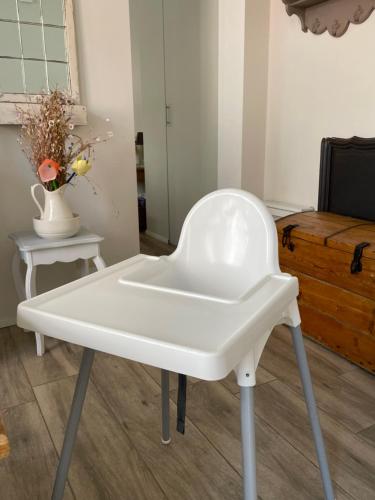 a white chair in a room with a table at Cosy house in a charming village in Beauvechain