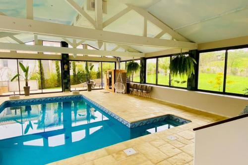 - une grande piscine dans une maison dotée de fenêtres dans l'établissement Maison avec piscine intérieure chauffée à 10min de Biarritz, à Ahetze