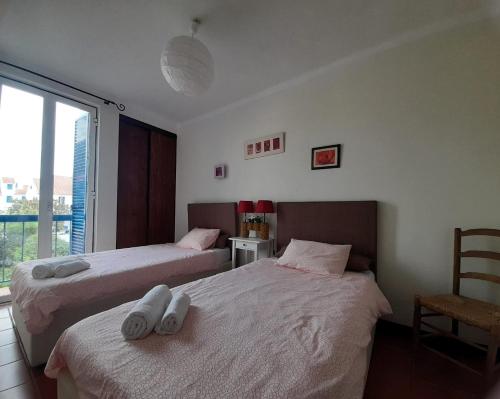 1 dormitorio con 2 camas con sábanas blancas y ventana en Villa Arrábida en Palmela