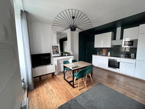 une cuisine avec une table et des chaises dans une pièce dans l'établissement Spacieux appartement Bordeaux, à Bordeaux