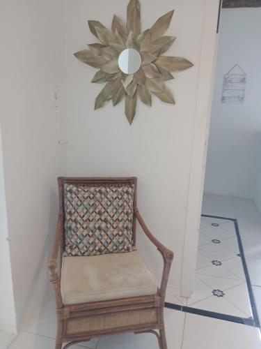 a chair in a room with a clock on the wall at Solar Lisboa 100 m da Praia com vista para mar in Balneário Camboriú