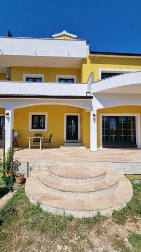 a yellow house with stairs in front of it at Krka Ivan in Lozovac
