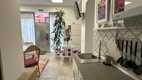 una cucina con un lavello e un tavolo con sedie di Pizarro 23, en el corazón de Cáceres a Cáceres