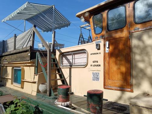 an old boat with a ladder and a house at Le logement du marinier in Eckwersheim