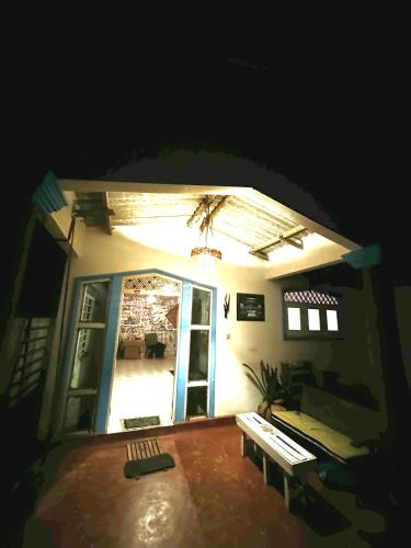 a dark room with a door and a room with a bench at Madiha Hostel by Land of Rizka in Matara