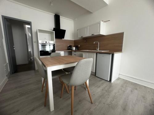 une cuisine avec une table et des chaises dans une pièce dans l'établissement Appartement cosy hyper centre, à Bar-le-Duc