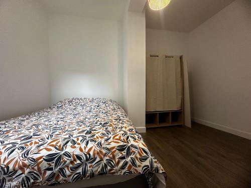 une chambre avec un lit avec une couette colorée dans l'établissement Appartement cosy hyper centre, à Bar-le-Duc