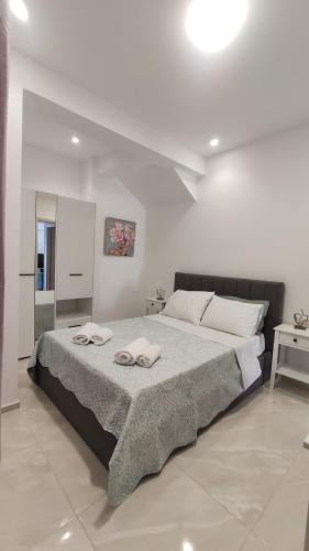 ein Schlafzimmer mit einem großen Bett mit zwei Handtüchern darauf in der Unterkunft Dream Houses in Perama