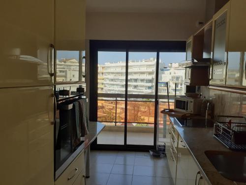 une cuisine avec vue sur un bâtiment depuis une fenêtre dans l'établissement Bel appartement, sublime vue mer, 2 terrasses, à Antibes
