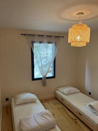 une chambre avec deux lits et une fenêtre dans l'établissement Maison en bois à Entrechaux, à Entrechaux