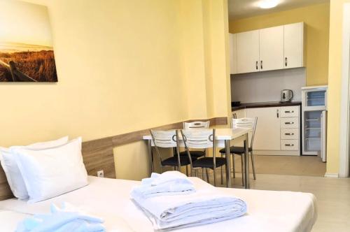 a room with two beds and a kitchen with a table at APART-HOTEL Stamopolu Lux с изглед към морето in Primorsko