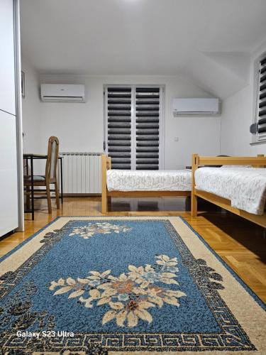 Habitación con 2 camas y alfombra azul en Villa Kasinda en Sarajevo