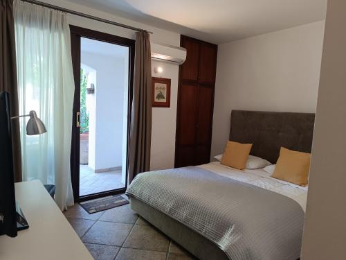 sypialnia z łóżkiem i dużymi szklanymi drzwiami w obiekcie B & B Villa Flora w mieście Mondello
