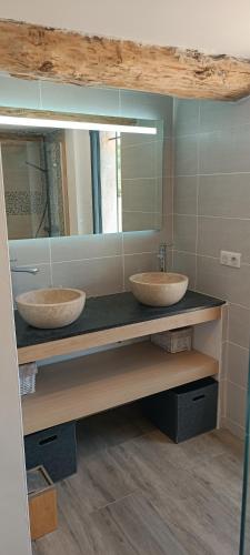 deux lavabos dans une salle de bain avec deux miroirs dans l'établissement Bergerie provençale, à Ampus