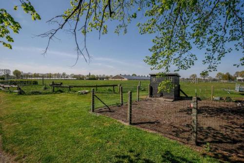 a farm with a fence and a field with animals at Camping De Nieuwe Hof in Otterlo