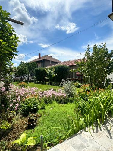 a garden with flowers in front of a house at Apartment Sunset Zone - Feels like home in Lozovo