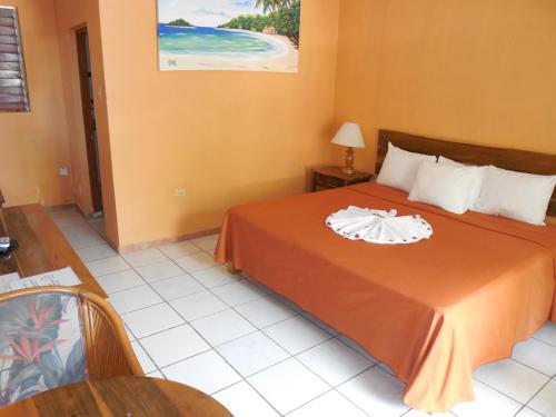 um quarto de hotel com uma cama com uma toalha em home sweet home resort em Negril