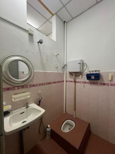 a bathroom with a sink and a toilet and a mirror at KHALiFAH HOMESTAY in Kampong Bugis