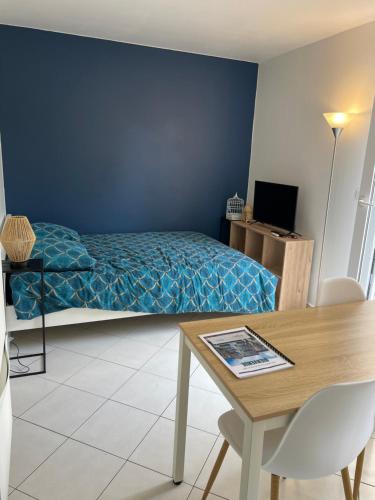 una camera con letto, tavolo e tavolo di Appartement avec jardin (25min DisneyLand Paris) a Chennevières-sur-Marne