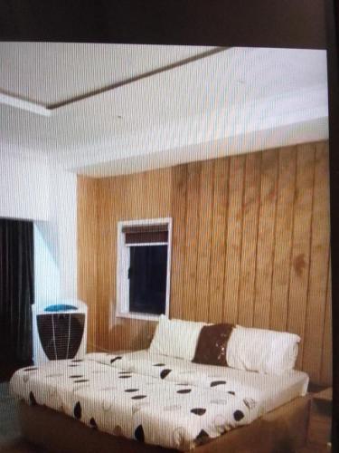 a bed in a bedroom with a wooden wall at N.V HOTEL AND RESORT BEACH view in Lagos