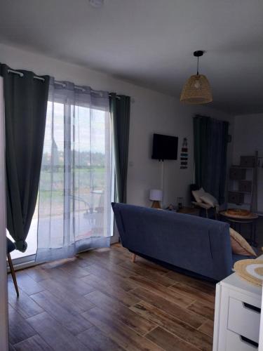 a living room with a couch and a large window at la petite maison in Lablachère