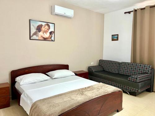 a hotel room with a bed and a couch at Tomi Apartments in Sarandë