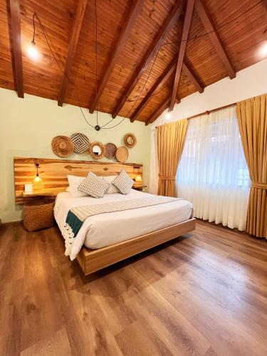 a bedroom with a large bed and a wooden ceiling at Sie Casa Hotel in Villa de Leyva