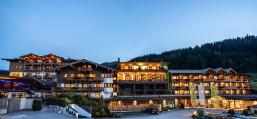 - un grand bâtiment éclairé dans une station de ski dans l'établissement Hotel Riederalm, à Leogang