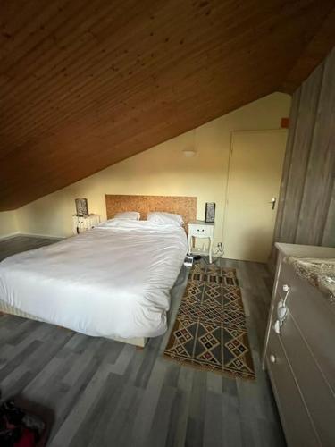 - une chambre avec un lit blanc et un plafond en bois dans l'établissement Maison de pêcheur au pied de la plage avec vélos, à Jard-sur-Mer