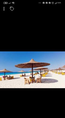 einen Strand mit Stühlen und einem Sonnenschirm auf dem Sand in der Unterkunft شالية ارضى فندقى قرية مينا 4الياحل الشمالى in Alexandria