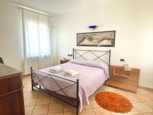 1 dormitorio con 1 cama con manta rosa y ventana en Teo Country House, en San Martino Siccomario