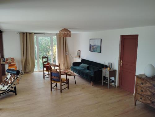 een woonkamer met een groene bank en stoelen bij Loft rez de jardin in Forcalquier