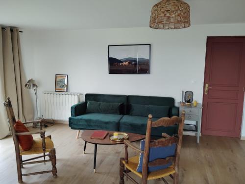 een woonkamer met een groene bank en een tafel bij Loft rez de jardin in Forcalquier