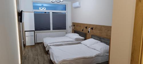 twee bedden in een kamer met een raam bij Ground Floor Rooms in Łomża