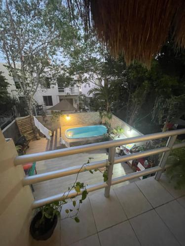 un balcon avec un banc et une piscine dans l'établissement Home's Jungle 15 Minutes from the Airport, à Cancún