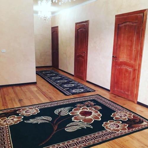 an empty room with rugs on the floor and two doors at Guest House Azaliya, Сары-Челек гостевой дом Азалия in Arkit