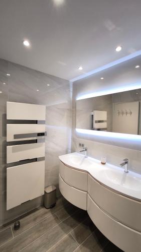 une salle de bain avec un lavabo blanc et un miroir dans l'établissement Le Riva - Standing, Parking, Piscine, Terrasse, à Cassis