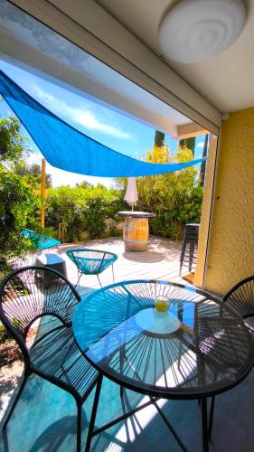 une table et des chaises en verre sur la terrasse dans l'établissement Le Riva - Standing, Parking, Piscine, Terrasse, à Cassis