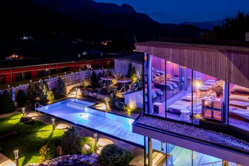 an aerial view of a building with a pool at night at Hotel Riederalm in Leogang