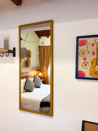 a mirror on a wall next to a bed at Sie Casa Hotel in Villa de Leyva